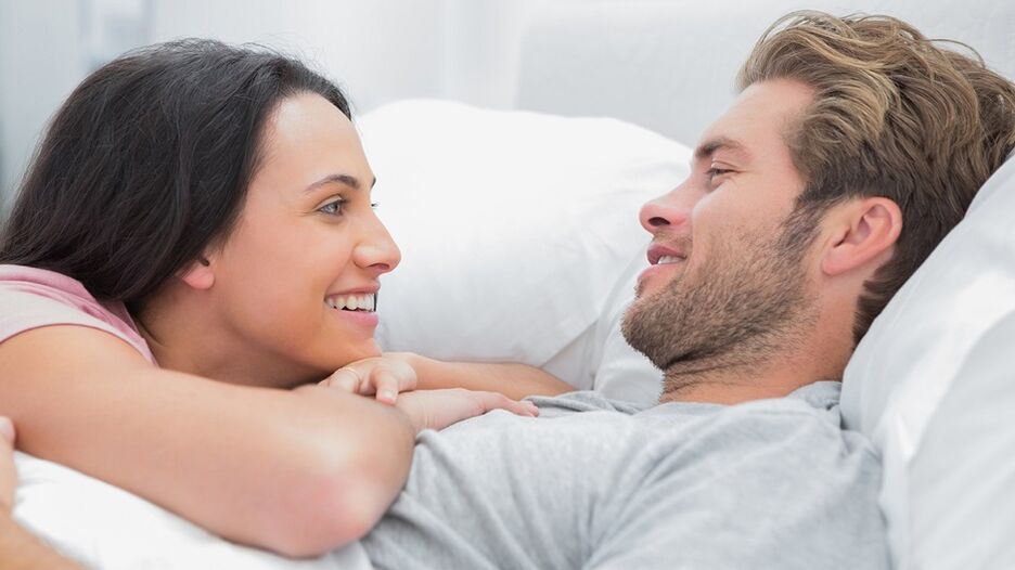 Happy woman with man in bed